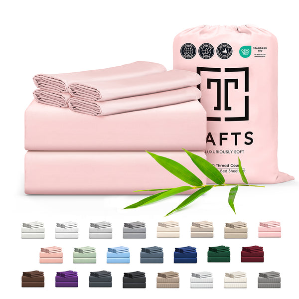 Pink bed sheets with packaging and bamboo leaves on a white background